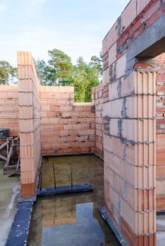 Interior of a Unfinished Red Brick House Walls under Construction without Roofing.