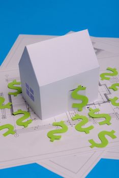 Paper skyscrapers , us dollar money, house projects plan and blueprints on blue background paper. Minimalistic and simple concept, style. Horizontal orientation. View from above. Copy space.