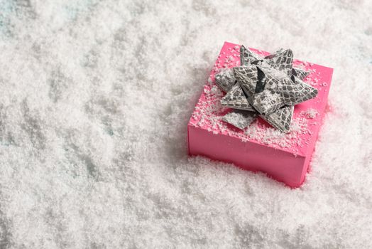 christmas presents nicely decorated with bows and feathers in snow. view from above