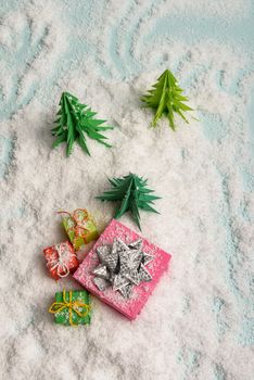 christmas presents nicely decorated with bows and feathers in snow. view from above