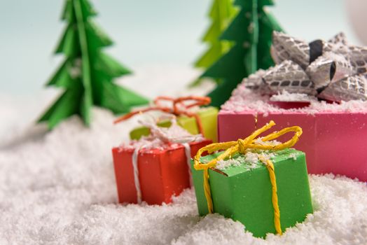 christmas presents nicely decorated with bows and feathers in snow. view from above
