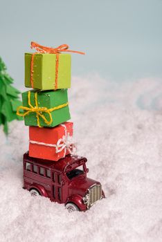 a toy car carries presents under the Christmas tree at snow. view from above. copy space