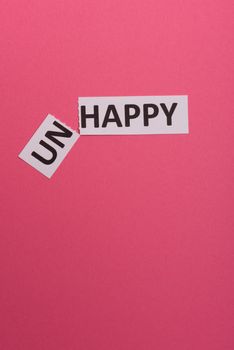 man hand holding card with text unhappy, cutting word 'un' so it written 'happy'. Copy space. Lime background. Studio shoot.