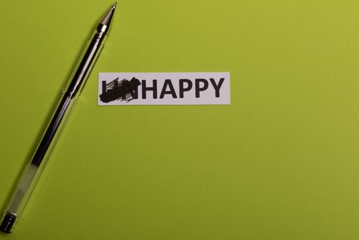 card with text unhappy, erease word 'un' so it written 'happy'. Copy space. Lime background. Studio shoot.