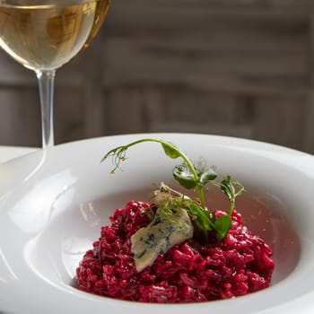 Beetroot risotto with blue cheese on a white plate