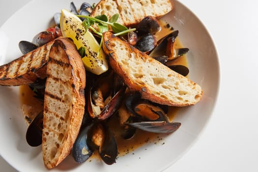 Seafood. Mussels in wine with croutons and lemon. Clams in the shells. Delicious snack for gourmands. Selective focus