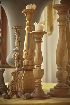 Many vintage wooden candlesticks made by hand and used as ornaments in a rustic home.