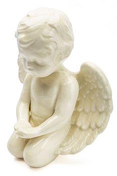 small figurine of white angel, kneeling with open wing