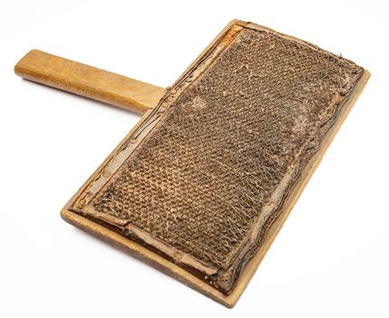 isolated wood wool carding comb against a white background