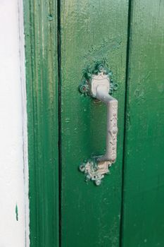 An old grip on a green door