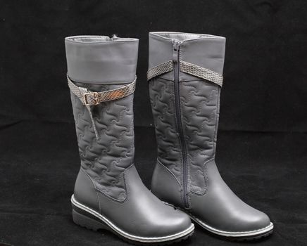 gray women's boots on black background