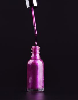 opened bottle of purple nail polish dripping