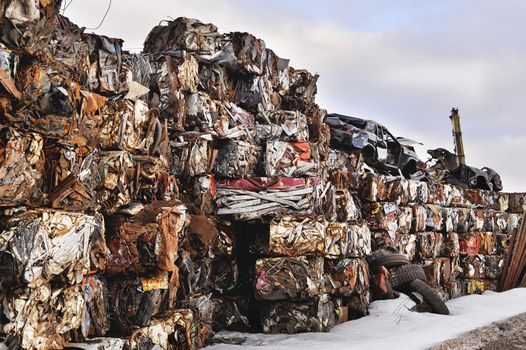 A pile of compressed cars in blocks for processing.