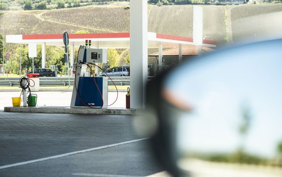 Gas station. Refueling car with Refueling car with gas pressure fuel. Gas loading column.  Car mirror.