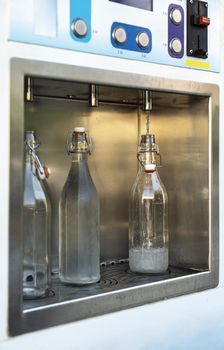 Mineral Water machine on the street. Filling mineral water bottles from a water dispenser. Pay and load drinking water.