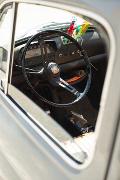 Steering wheel on vintage car. View from the door window. Opened window on old vintage car.