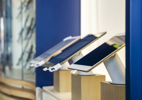 Cell Phones on shelf in telecommunication shop. Lights over GSM phones. Showcase in store for technology devices. Concept for communication and data.