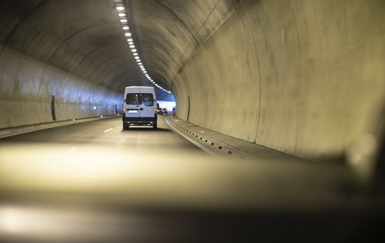 Bus traveling in highway tunnel. Tunnel lights.