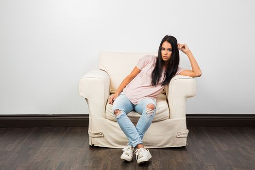 mid-twenties woman, sitting on a couch with casual clothes