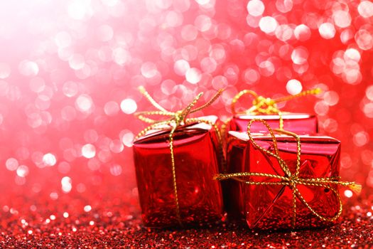 Small decorative gift boxes on shiny glitter background