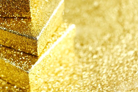 Stack of Gold decorative boxes with holiday gifts on abstract gold background