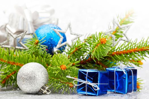 Christmas card with fir tree branch and decoration on silver glitter background