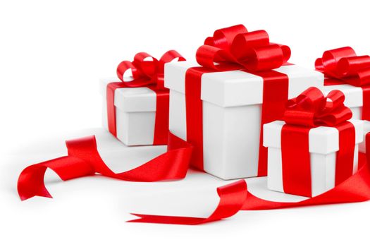 White gift boxes with red ribbon bows isolated on white background close-up