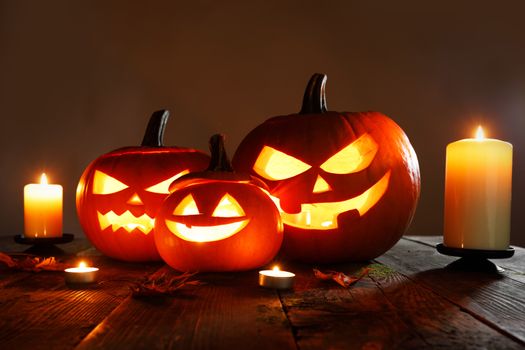 Halloween pumpkin head jack o lantern and candles on gray background