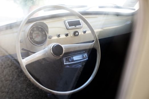 White interior of vintage car. White steering wheel.