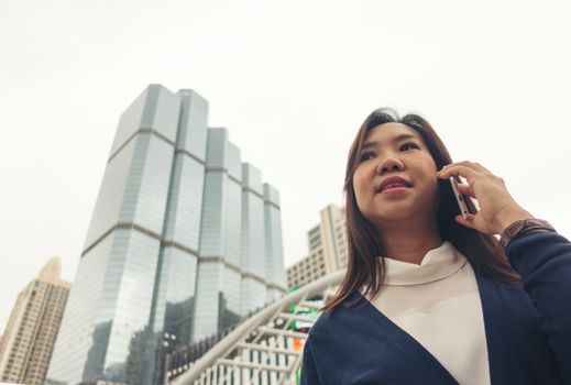 businesswoman walking outdoor and talking on mobile phone