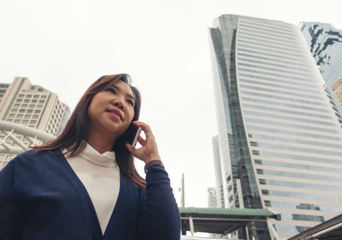 businesswoman walking outdoor and talking on mobile phone