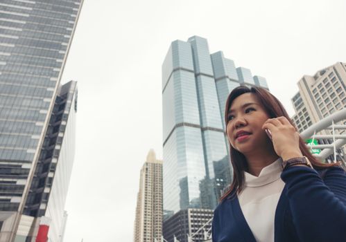 businesswoman walking outdoor and talking on mobile phone