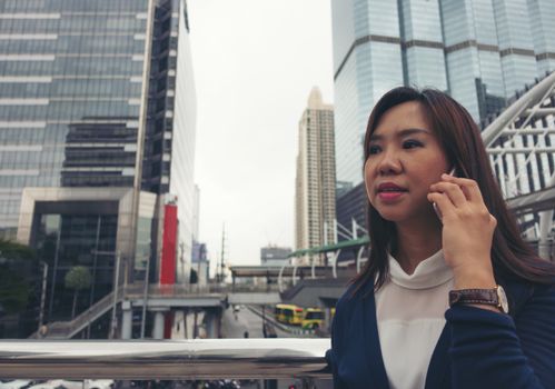 businesswoman walking outdoor and talking on mobile phone