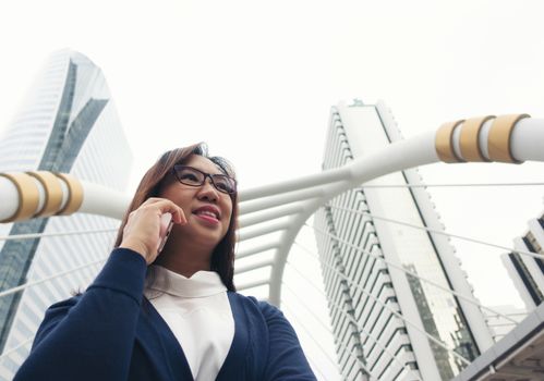 businesswoman walking outdoor and talking on mobile phone