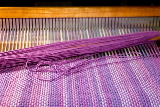 detail of fabric in comb loom with ultraviolet and lilac colors