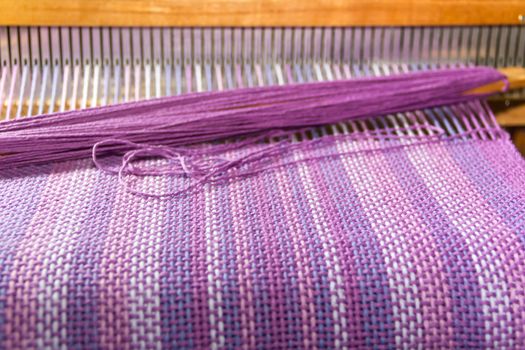 detail of fabric in comb loom with ultraviolet and lilac colors