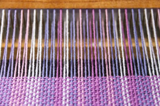 detail of fabric in comb loom with ultraviolet and lilac colors