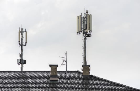 5G antennas on top of house. Antennas and transmitters on roof. High speed mobile internet concept.