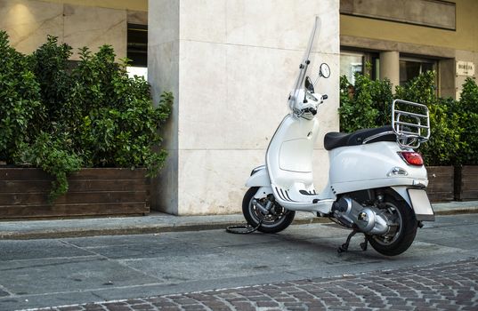 White italian scooter on italian street. Typical italian architecture on background. Typical italian motorbike style.