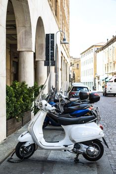White italian scooter on italian street. Typical italian architecture on background. Typical italian motorbike style.
