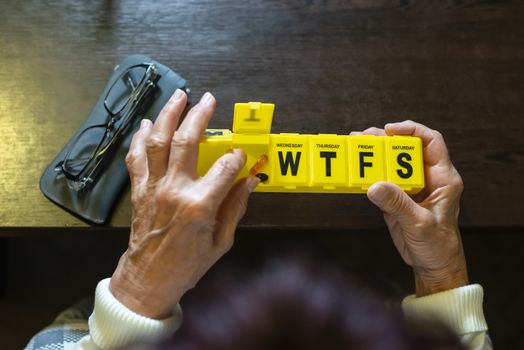 Senior woman take pills from box. Healthcare and old age concept with medicines. Medicaments on table.