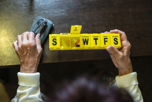 Senior woman take pills from box. Healthcare and old age concept with medicines. Medicaments on table.