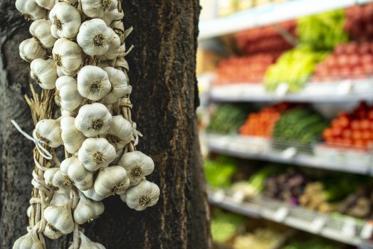 Bundle garlic hung on hang in vegetable market.