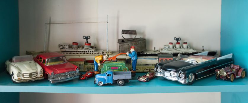 Old vintage toys on shelf. Collection of vintage cars toys in a shop. Bright colours.