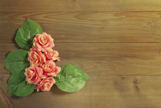 top view beautiful flowers with leaves on wooden background