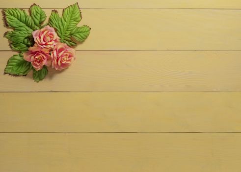 top view beautiful flowers with leaves on wooden background