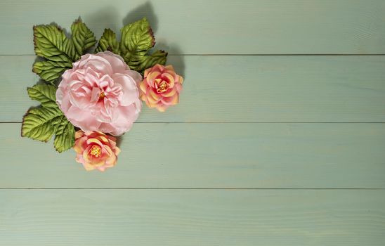 top view beautiful flowers with leaves on wooden background