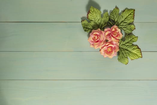 top view beautiful flowers with leaves on wooden background