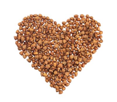 Pile of buckwheat in the shape of heart isolated on white background with clipping path