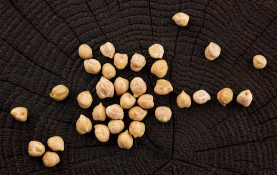 Chickpeas on black wooden background, top view